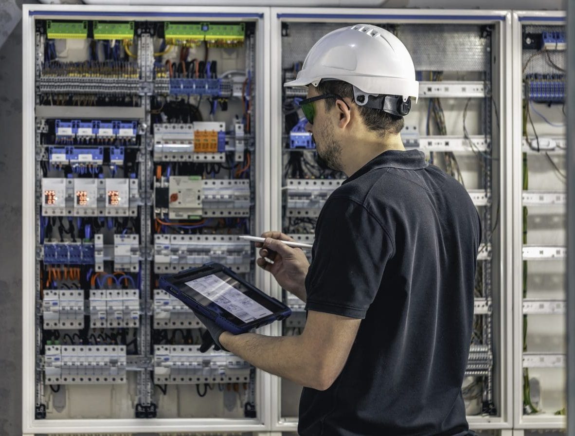 a commercial electrician working in a switchboard with fuses